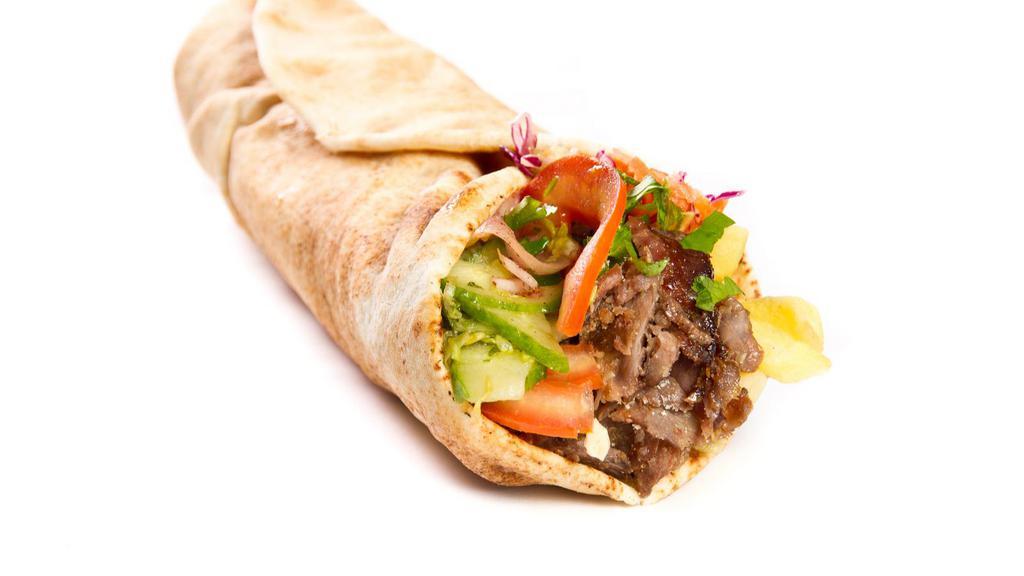 Beef Shawarma Wrap · A flour tortilla with skirt beef steak, red onions, parsley, sumac mix, diced tomatoes, pickled cucumbers, tahini sauce, and hummus spread.