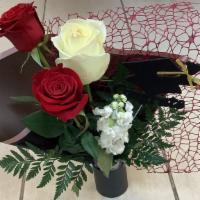 Graduate Arrangement   · Three South American Roses with stock flowers and leather leaf wrapped in a black and dark r...