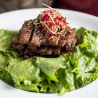 Kalbi · Grilled beef short ribs, mild soy sauce, scallion, green leaf, soy bean paste dressing.