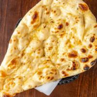 Naan · Unleavened white bread topped with butter.