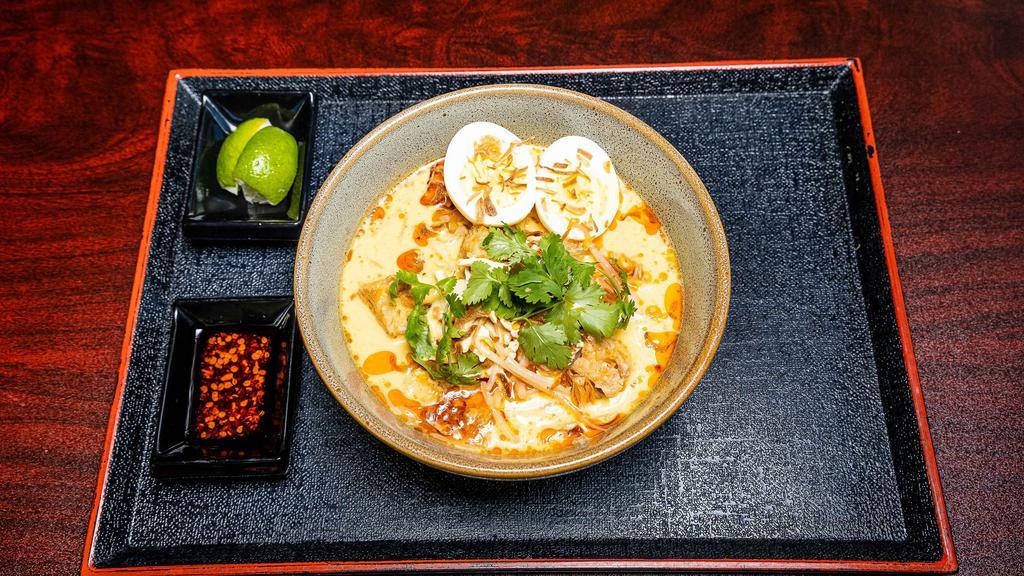 Curry Laksa Noodle Soup · Spicy. Rice noodles served in yellow and red curry broth, chicken breast, bean sprouts, hard-boiled eggs, fried bean curd, fried shallots, lime and roasted chili sauce.