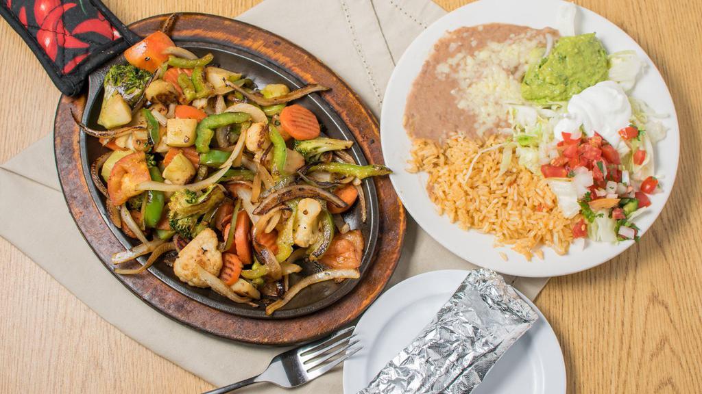 Fajitas Vegetarian · Large onions, peppers, cauliflower, broccoli, carrots, and tomatoes, covered with shredded cheese.