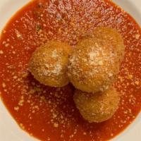Risotto Balls · Fried arborio rice stuffed with fontina served over gravy.
