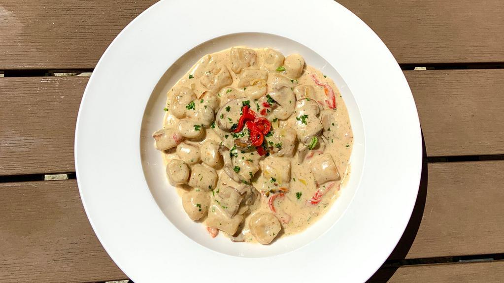 Gnocchi · House-made potato gnocchi, local mixed mushrooms, roasted red peppers, leek cream sauce, finished with truffle oil drizzle.