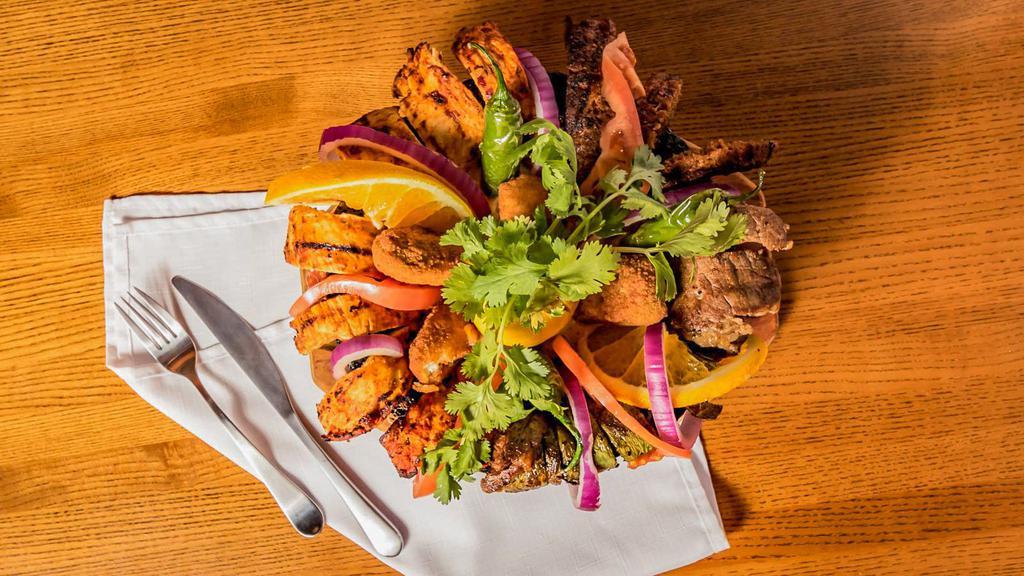Molcajete (Our Signature Dish) · Grilled shrimp, nopales (cactus), stuffed jalapeno, beef and chicken fajitas, smoked chorizo, grilled onion, pico de gallo, sour cream, rice, beans and tortillas, salsa and cheese on the bottom of a stone molcajete bowl.