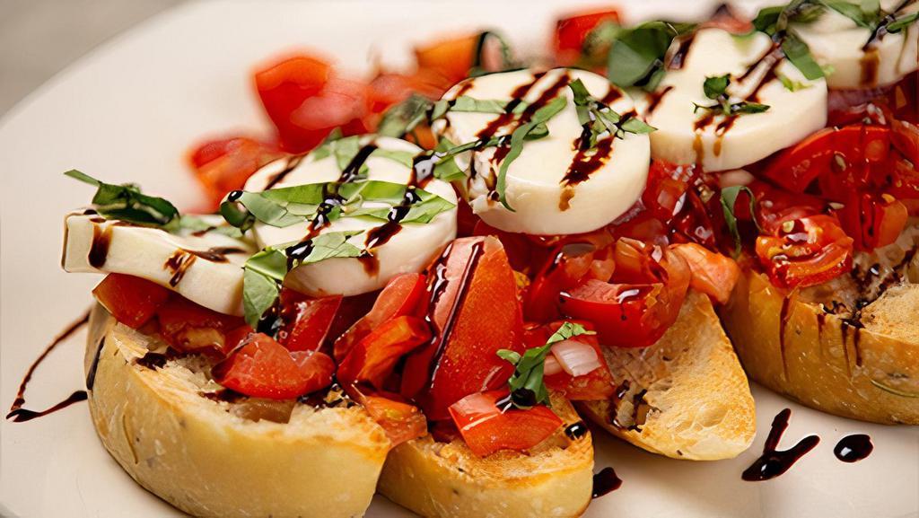 Bruschetta · marinated roma and sun-dried tomatoes topped with fresh housemade mozzarella served over focaccia toast and drizzled with balsamic glaze