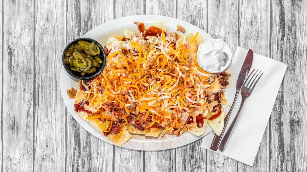 Bbq Nachos · Warm chips topped with pulled pork, cheese dip, Corky's famous BBQ sauce, dry rub and a side of sour cream.