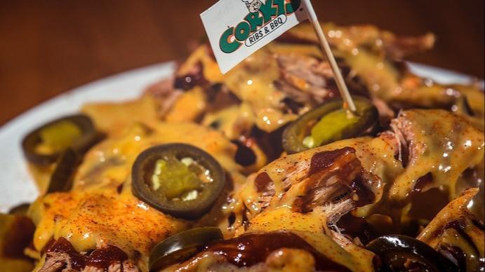 Pork Nachos - Full Order · Crisp tortilla chips loaded with pulled pork and topped with El Terrifico cheese sauce, Corky's Original BBQ sauce, Corky's Dry Rub, and Jalapenos.