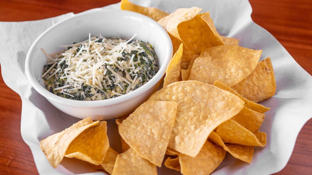 Spinach & Artichoke Dip · Unbelievable cream spinach and artichoke dip topped with freshly grated Parmesan cheese and served with our warm tortilla chips.