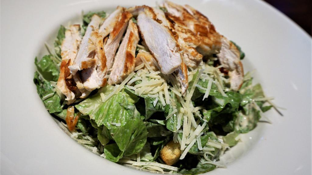Chicken Caesar Salad · Lightly marinated grilled chicken breast served over crisp romaine lettuce tossed with caesar dressing and Parmesan cheese.