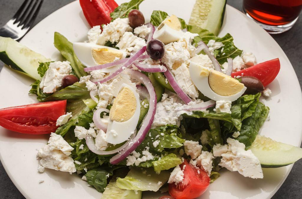 Greek Salad · Romaine lettuce and roma tomato and cucumber and green pepper and feta and kalamata olives and Bermuda onions and tzatziki sauce and egg in a balsamic vinaigrette.