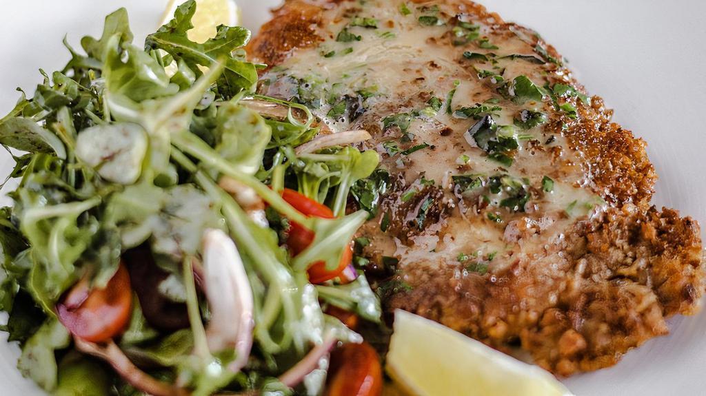 Chicken Milanese · Pan seared breaded chicken breast with baby arugula and cherry tomato
