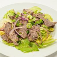 Tiger Tear Salad (Yum Nur) · Grilled medium rare beef, tossed with chili peppers, lime juice, crushed rice powder and oni...