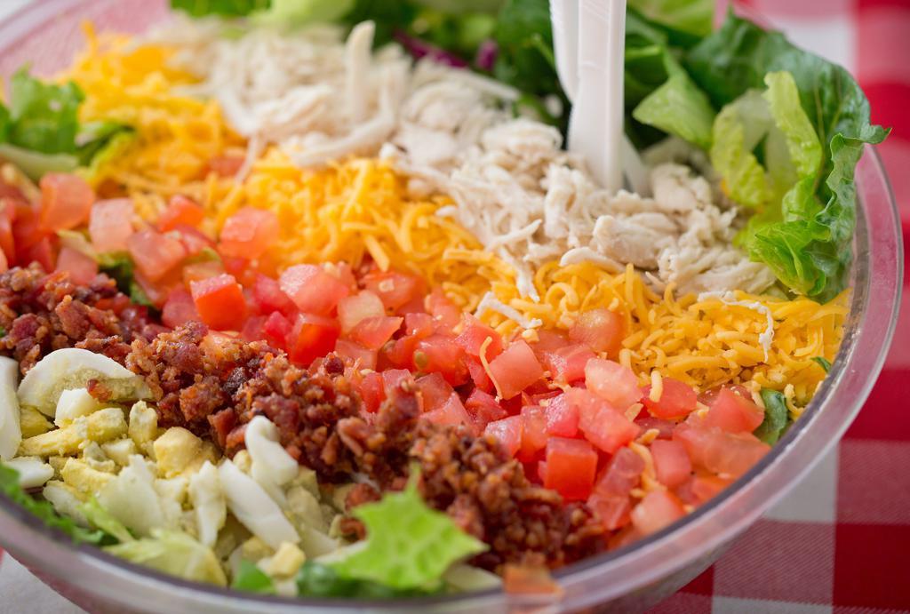 Cobb Salad · Fresh spinach & mixed greens topped with bacon, scallions, egg, shredded chicken, tomato & grated cheddar cheese.