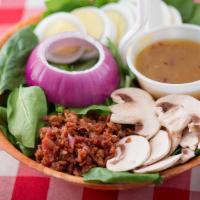 Spinach Salad · Fresh spinach topped with egg, mushroom, and red onion, served with a side of bacon bits and...