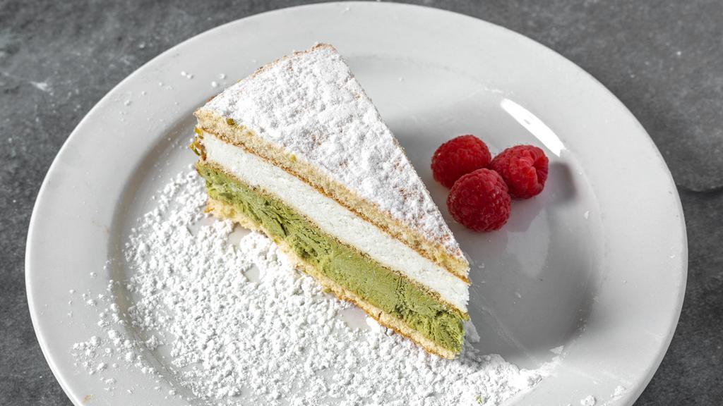 Ricotta E Pistachio Imported · Pistachio and ricotta creams separated by sponge cake, decorated with crushed pistachios and dusted with powdered sugar.
