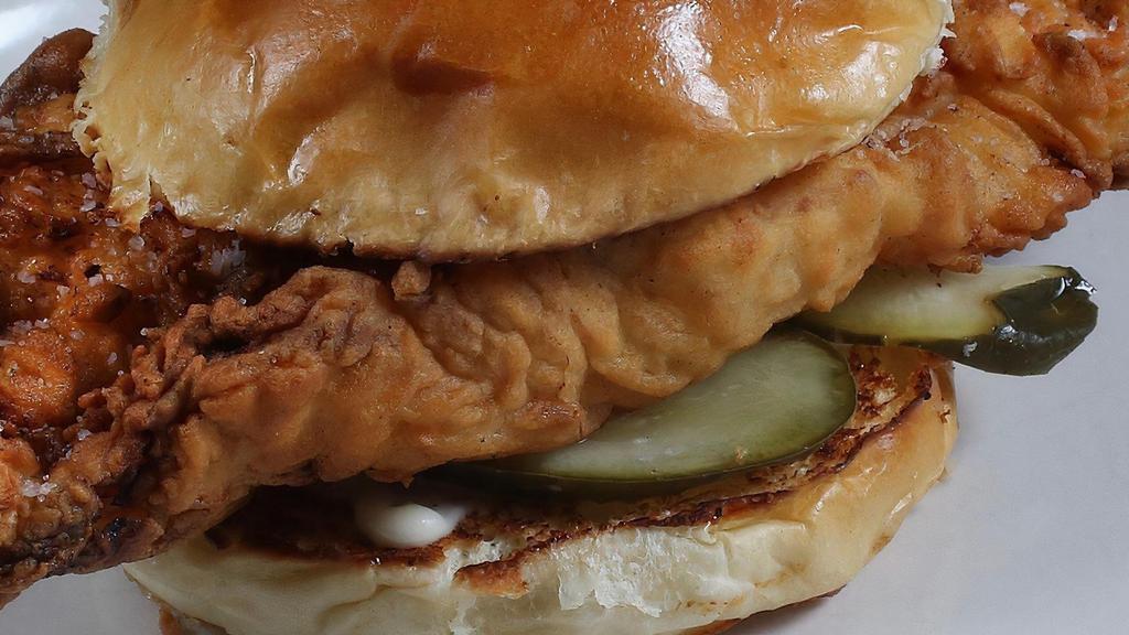 Fried Chicken Sandwich · Breast meat chicken fried golden brown with a roasted garlic aioli and house pickles, served on a fresh baked brioche bun.
