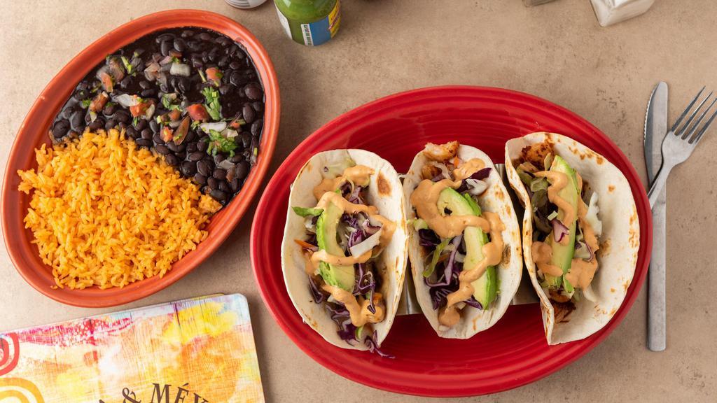 Shrimp Tacos · Three tacos with shrimp, served in flour tortillas with carrots, cabbage, sliced avocado and our delicious creamy chipotle sauce. Served with black beans and Spanish rice on the side.
