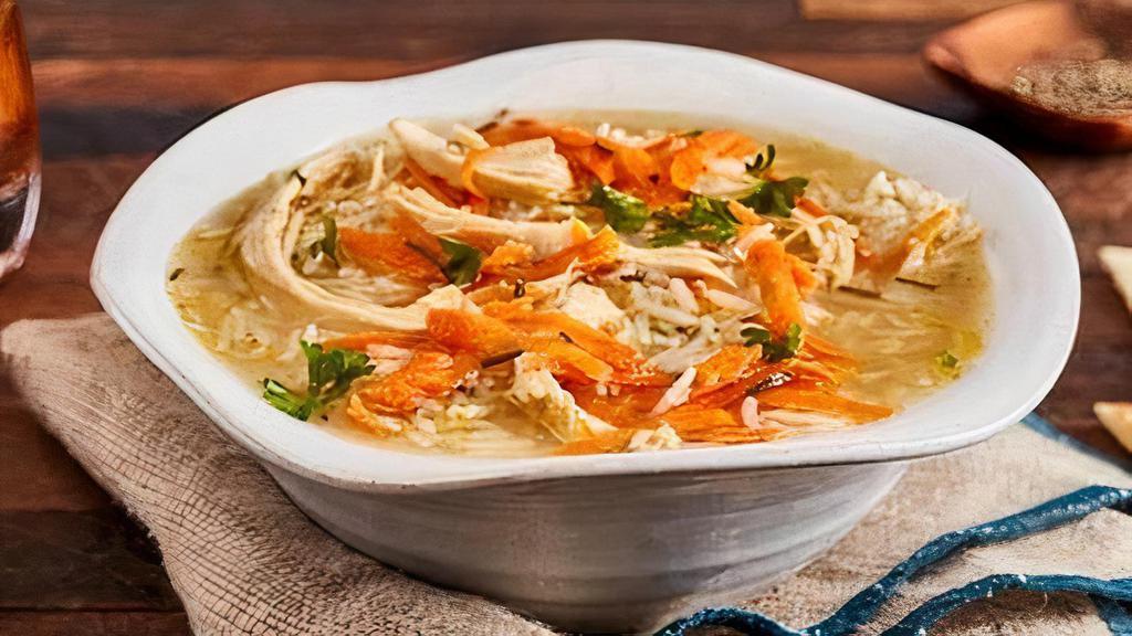 Greek Lemon Chicken Soup · Bowl of our fresh homemade lemon chicken soup served with soft pita