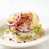 Wedge Salad · Crisp iceberg lettuce wedge, topped with bacon bits, sliced red onion and our famous homemad...