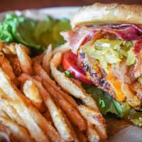Nashville Hot Burger · Topped with Nashville Hot Sauce, cheddar cheese, caramelized onions, chopped pickles, and ba...