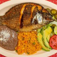 Mojarra Frita · Fried fish and rice and beans and a salad.