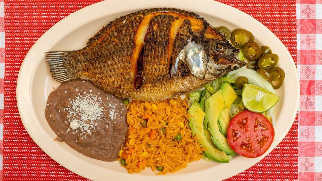Mojarra Frita · Fried fish and rice and beans and a salad.