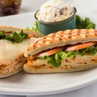 Smoky Chipotle Chicken Panini · Sliced chipotle chicken panini on pressed ciabatta served with lettuce, tomatoes, provolone ...