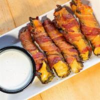 Bacon-Wrapped Jalapeños (App) · Hickory-smoked jalapenos stuffed with Monterey Jack & wrapped in bacon.  Served with butterm...