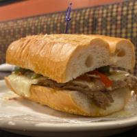 K’Bolá Philly Cheesesteak · Our k'Bola Philly cheesesteak is a sandwich made with super thinly sliced ribeye steak, red ...