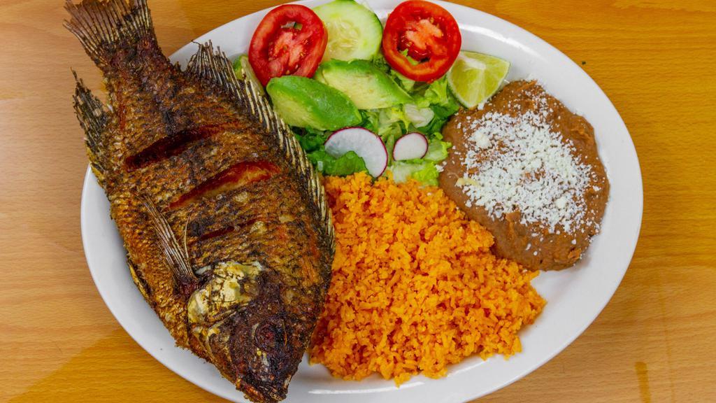 Mojarra · Fried whole tilapia With A Side Of Rice, Beans, And A Small Salad