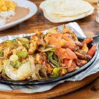 Fajitas De Pollo · Marinated chicken breasts, seared and thinly sliced, served with grilled onions, tomatoes an...