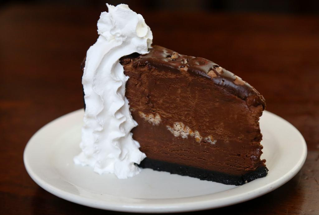 Chocolate Mousse Cake · For the chocolate lover! Chocolate cake and chocolate mousse layered together with a chocolate cookie crust and toasted almonds.