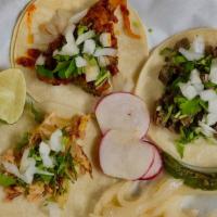 Corn Tortilla Tacos · a taco with the meat of your choice topped with cilantro and onions