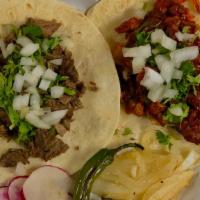 Flour Tortilla Tacos · a taco with the meat of your choice topped with cilantro and onions