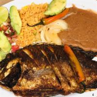 Fried Fish (Mojarra) · Big Fried fish Served with rice,  beans, lettuce, avocado, lemon, fried pepper, and tortillas