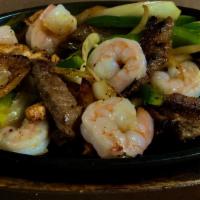 Mix Fajitas · Chicken, Beef, and Shrimp mixed with green peppers and onions and a side of rice, beans, let...