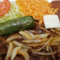Carne Asada · Bistec asado con cebollas, arroz, frijoles, ensalada y tortillas / fried steak with onions s...