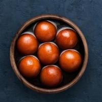 Gulab Jamun  · 4 pieces of soft berry sized balls soaked in rose flavored sugar syrup.