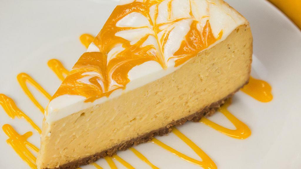 Mango Topping Over Cheesecake · New York-style cheesecake on top of a graham cracker crust. Topped with mango topping.
