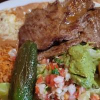 Carnitas · Golden pork tips, served with rice, beans, salad, and tortillas.