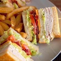 Turkey Club Sandwich · Slow-roasted turkey breast, hickory-smoked bacon, American and Swiss cheeses on grilled sour...