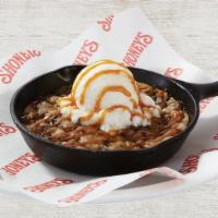 Skillet Cookie · A freshly baked delicious soft and warm chocolate chunk cookie drizzled with rich sea salt c...