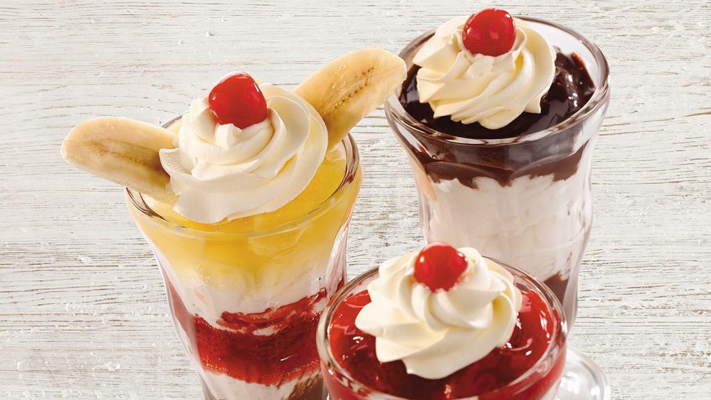 Classic Sundaes · Our sundaes are made with scoops of vanilla bean ice cream and finished with whipped topping and a cherry.