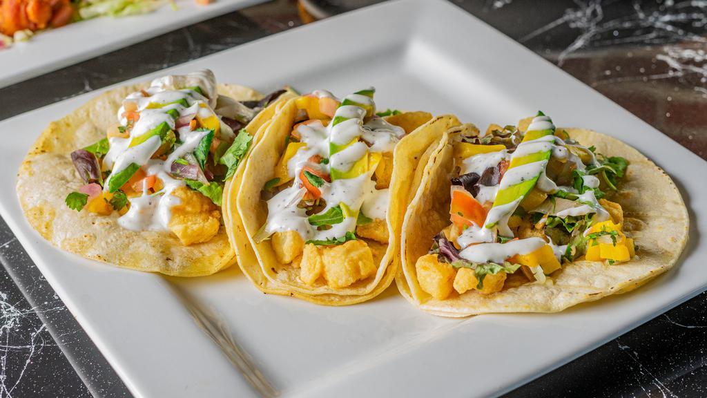 Baja Tacos · Three corn tortillas filled with crispy deep fried cod fish, fresh mixed greens, mango salsa with avocado and our creamy yogurt dressing. served with rice and refried beans.