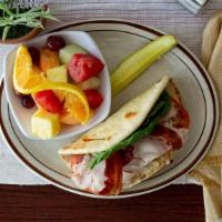 California Turkey Sandwich · Grilled pita bread with warmed turkey, bacon strips and melted gruyere cheese, cool mayo, le...