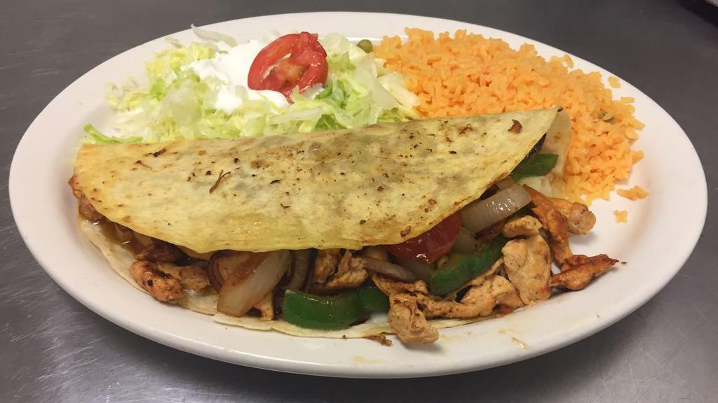 Fajita Quesadilla · A big n inch quesadilla filled with your choice of meat grilled with bell peppers, onions, and tomatoes. Served with Spanish rice, lettuce, guacamole, sour cream, and tomato.