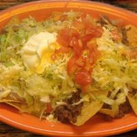 Nachos Supreme · Nachos with ground beef, shredded chicken and refried beans. Topped with cheese sauce, lettu...
