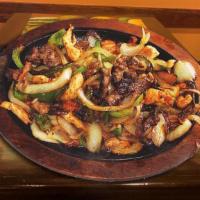 Mixed Fajitas · Tender- sliced beef and chicken breast with bell peppers, onions, and tomatoes served with g...