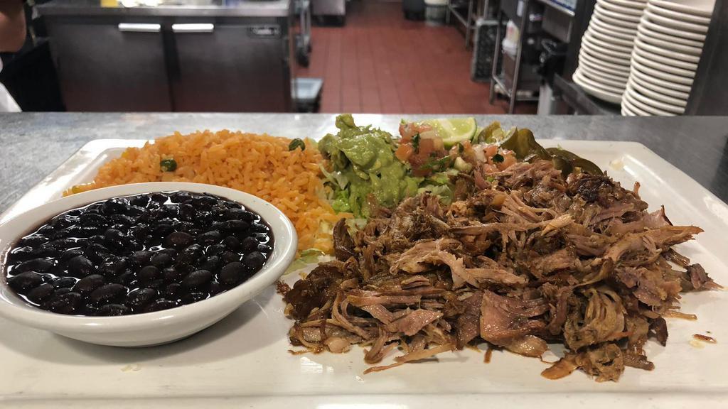 Carnitas · Fried pork meat served with refried beans, Spanish rice, tortillas, pico de gallo, lettuce, and guacamole.